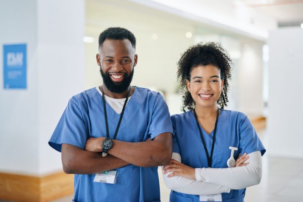 Doctor, nurse and hospital team in scrubs while on duty at the medical center. Portrait of black healthcare career professionals with smile and folded arms ready for work at the clinic.
